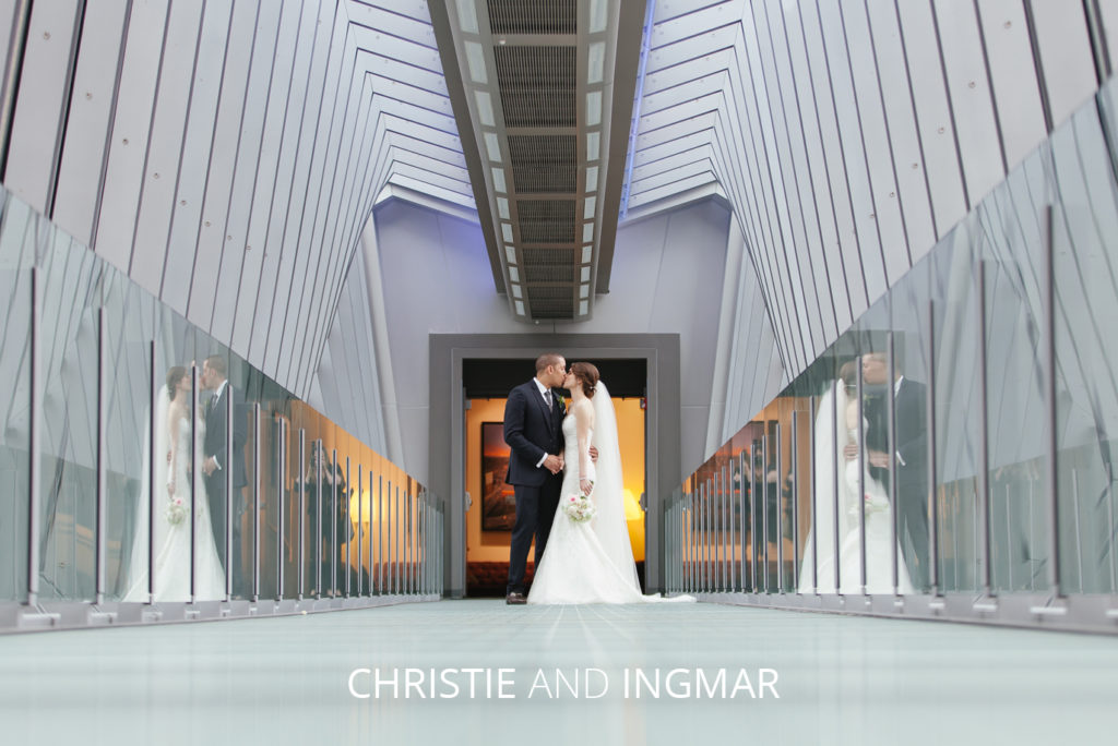bride and groom kissing on hilton skywalk