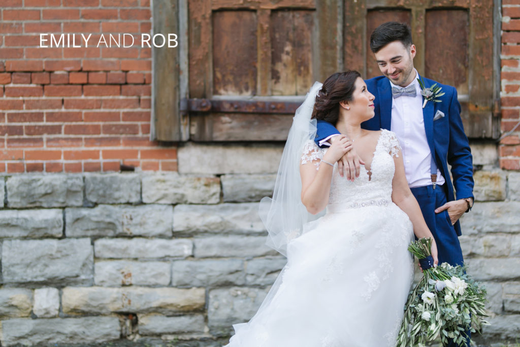 Emily and Rob | Jessica Miller Photography bride and groom smiling at eachother in front of brick wall