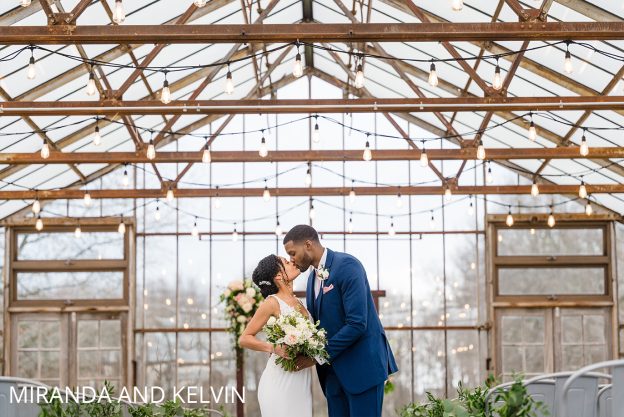 bride and groom kissing in greenhouse